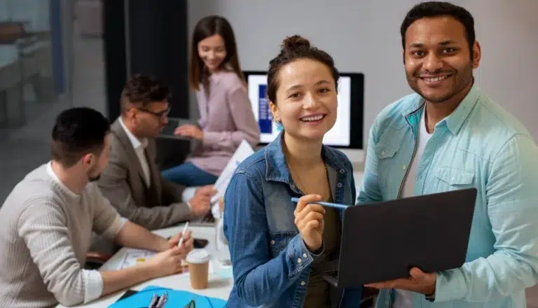 Group of professionals collaborating with a laptop in a modern office setting.